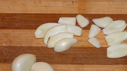 1. Этап. Свиная шея, запеченная в фольге: Чеснок очищаем и нарезаем тонкими ломтиками.