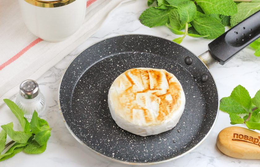 1. Этап. Жареный камамбер с брусничным соусом: Когда соус загустеет, сбрызните сковороду растительным маслом и прогрейте ее на плите. Затем нагрев убавьте до среднего и выложите камамбер. Обжарьте сыр по 2-3 минуты с каждой стороны до румяности, пока он не станет внутри мягким.