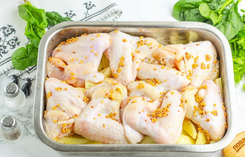 1. Этап. Крылышки в медово-горчичном соусе в духовке: По желанию крылья можно запечь с гарниром из картофеля — в таком случае гарнир располагайте снизу в форме, чтобы жир с крыльев пропитывал его. Выложите крылья в форму и сбрызните растительным маслом для получения красочной корочки. Отправьте в разогретую духовку на 40-45 минут при 200 градусах.