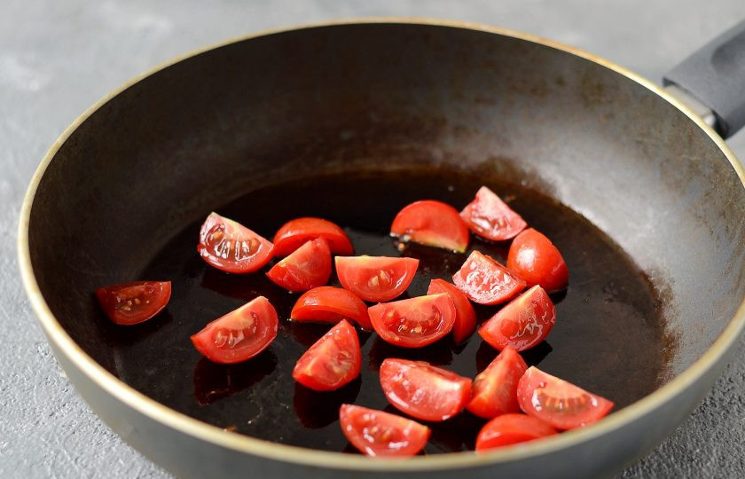 1. Этап. Черемша с томатной пастой: Разогрейте сковороду на среднем огне. Добавьте нарезанные на четвертинки помидоры черри. Жарьте пару минут до мягкости.