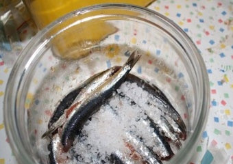 1. Этап. Засолка хамсы: 5. С рыбы слейте образовавшуюся жидкость и понемногу выкладывайте ее в подготовленную емкость, пересыпая слоя солью.