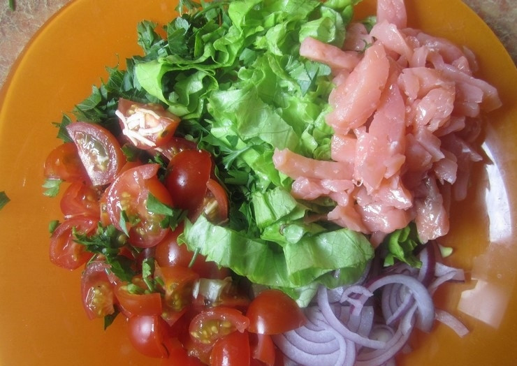 1. Этап. Салат из соленой семги: 1. Мою все овощи, зелень и вытираю бумажным полотенцем. Листья салата и петрушку мелко нарезаю, помидоры разрезаю на 4 части, а несколько штучек оставляю для украшения. Лук чищу и нарезаю полукольцами, а рыбу нарезаю тонкими кусочками. Все ингредиенты складываю в тарелку.