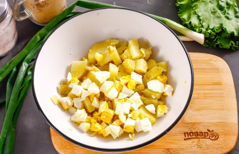 1. Этап. Салат с копченой курицей и авокадо: Очистите куриное яйцо и картофель от скорлупы, кожуры, промойте в воде. Нарежьте средними или мелкими кубиками и высыпьте обе нарезки в глубокую емкость.