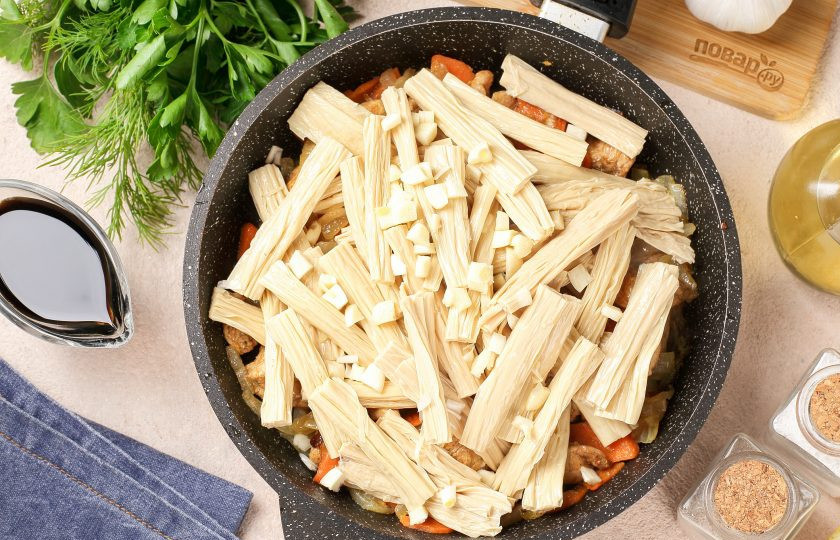 1. Этап. Жареная соевая спаржа с курицей: Добавьте спаржу и измельчённый ножом чеснок.