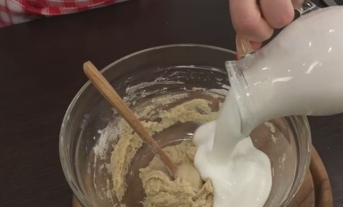 1. Этап. Очень вкусный домашний хлеб на кислом молоке: 3. Когда в тесте появятся пузырьки, отправьте в него скисшее молоко и хорошо перемешайте сначала ложкой, а потом венчиком.