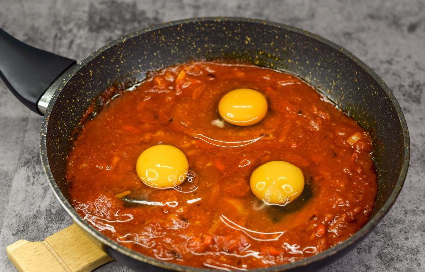 1. Этап. Шакшука: Вбейте в сковороду куриные яйца. Посолите немного яйца.