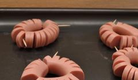 1. Этап. Рис с сосисками: Сворачиваем надрезами наружу и скрепляем зубочисткой. Выкладываем на противень, смазанный растительным маслом.