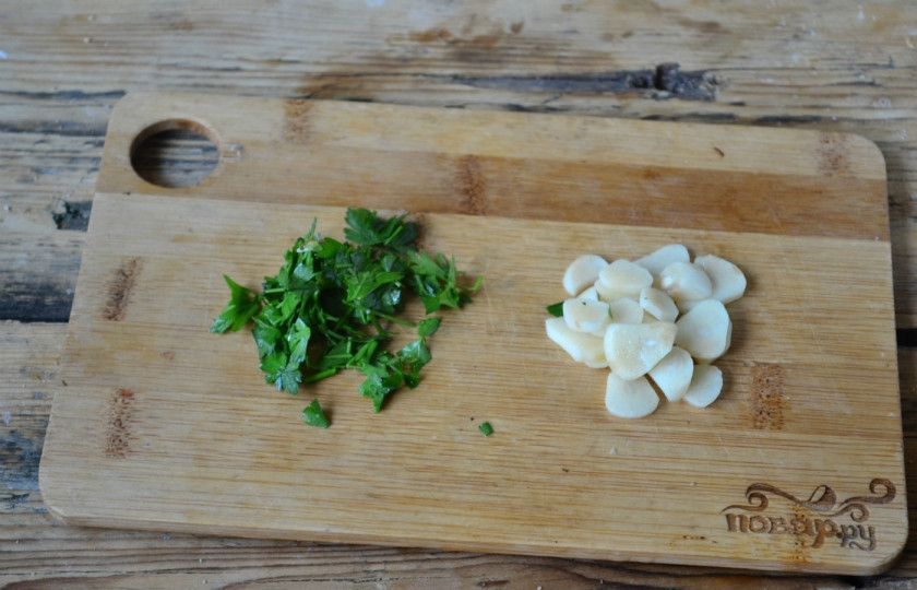 1. Этап. Рыбное филе под соусом: Чеснок порежьте тонкими пластинами, а зелень мелко порубите.