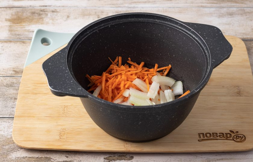 1. Этап. Овощной суп с рисом и морской капустой: Репчатый лук нарежьте полукольцами, морковь очистите и натрите на терке. Разогрейте в кастрюле с толстым дном растительное масло и обжарьте овощи до мягкости и золотистого цвета 4-5 минут.