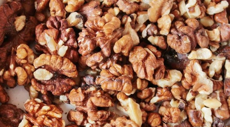 1. Этап. Салат с гранатом и орехами: Ядра грецких орехов выложите на противень и прокалите их в духовке. Также можно поджарить орешки на сухой сковороде. Нарубите ядра ножом на более мелкие кусочки.