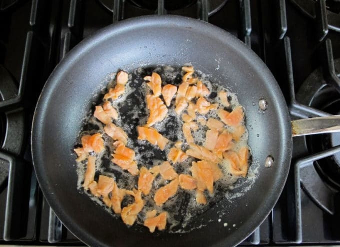 1. Этап. Скрэмбл с лососем: 3. Потом выложите в неё рыбу кусочками. Обжарьте её 1 минуту.