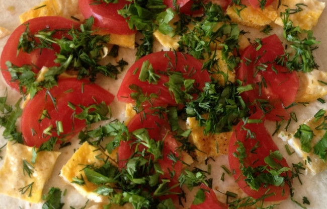 1. Этап. Жареные конвертики из лаваша: Сверху выкладываем порезанный томат и мелко нарезанную зелень. Сворачиваем лаваш конвертиком.