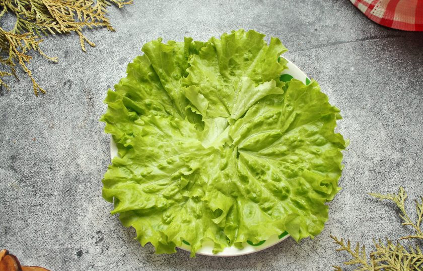 1. Этап. Салат с красной рыбой и креветками слоями: Разложите листья салата на сервировочном блюде.