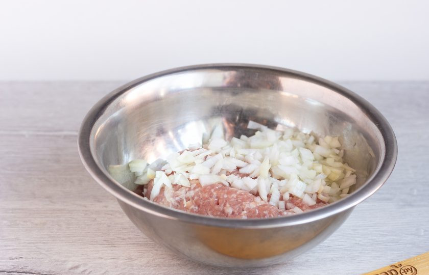 1. Этап. Яичный рулет со свининой и базиликом: Пока выпекается омлет, мелко нарежьте лук и перемешайте с фаршем. Посолите по вкусу.