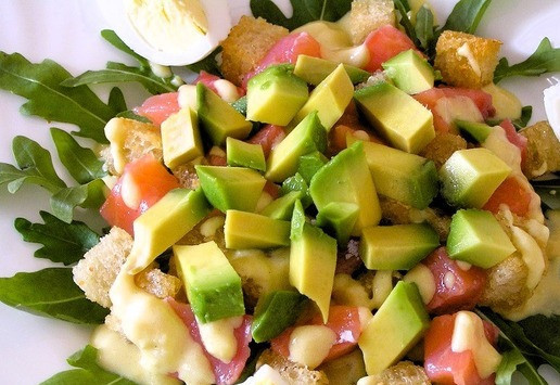 1. Этап. Салат Цезарь с семгой: Сверху выложите нарезанное кусочками авокадо и четвертинки яиц.