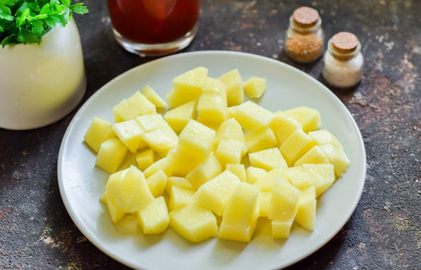 1. Этап. Борщ с лечо: Картофель очистите и вымойте, просушите. Нарежьте картофель средними кубиками. Переложите картофель в кастрюлю, залейте водой, варите 20 минут.