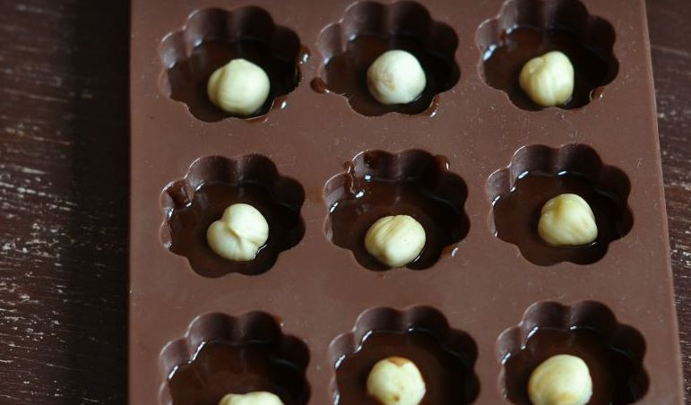 1. Этап. Конфетки: В каждую емкость выложите по одному орешку фундука. Орешки прекрасно дополнят конфеты, сделают их намного интереснее и вкуснее.