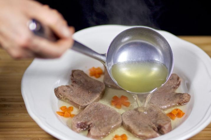 1. Этап. Язык заливной: 6. Нарежьте говяжий язык аккуратными ломтиками и разместите на блюде. Залейте мясо бульоном и дайте остыть в холодильнике. Приятного аппетита!