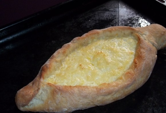 1. Этап. Аджарские хачапури Лодочка: 9. Противень смажьте маслом и присыпьте мукой. Выложите туда хачапури и отправьте в хорошо разогретую духовку минут на 12-15.