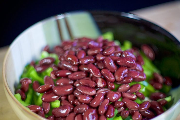 1. Этап. Cалат с крабовыми палочками и фасолью: Слейте воду из банки с консервированной фасолью. Затем выложите фасоль в салатницу.