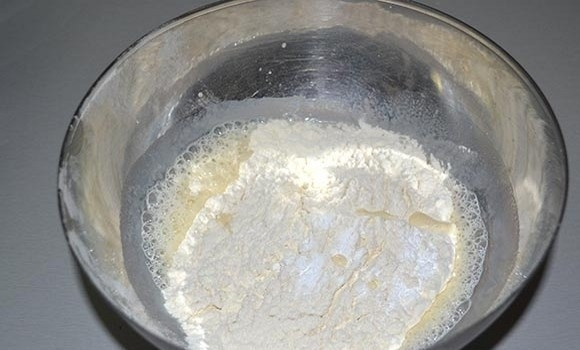 1. Этап. Вкусные оладушки: Затем добавьте просеянную муку, разрыхлитель и продолжайте взбивать миксером.