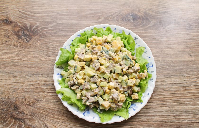 1. Этап. Салат с языком и кедровыми орешками: Переложите салат из миски на листья салата.