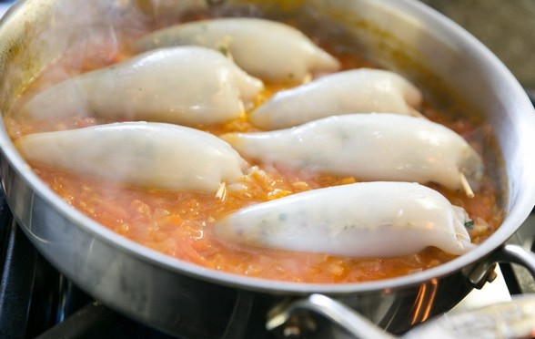 1. Этап. Кальмары с рисом: 8. Выложите кальмары в соус и тушите на среднем огне минут 20. Перед подачей аккуратно нарежьте тушки, присыпьте зеленью и по желанию тертым сыром. Приятного аппетита!