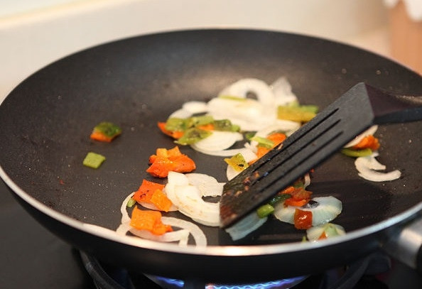 1. Этап. Жареная говядина с овощами: 10. Добавьте в сковороду 1-2 ложки масла и обжарьте до мягкости нарезанный лук и болгарский перец. На это уйдет минуты 4-5. Не забывайте помешивать.