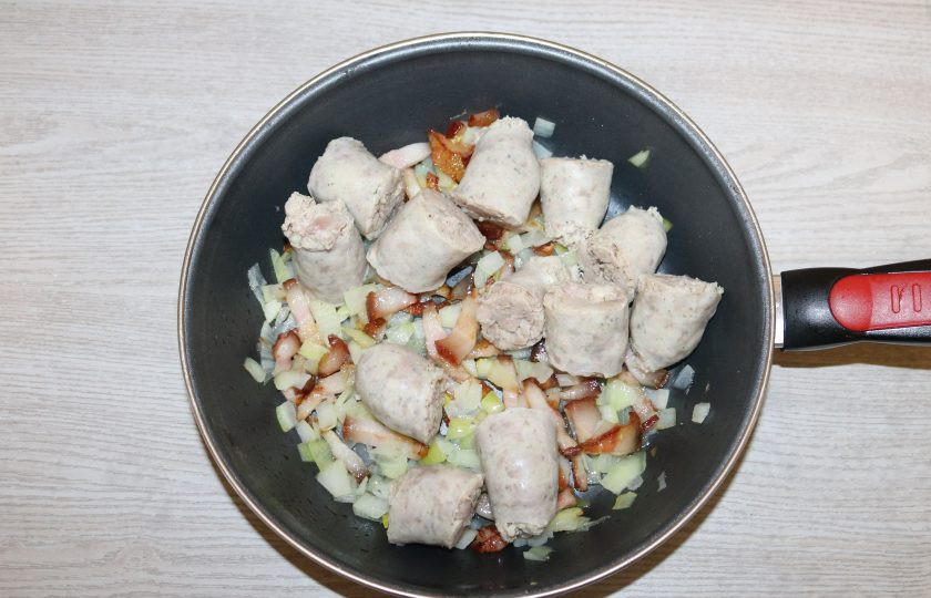 1. Этап. Коддл: К обжаренному бекону и луку добавьте колбаски, выключите огонь, перемешайте. Оставьте на 8-10 минут.