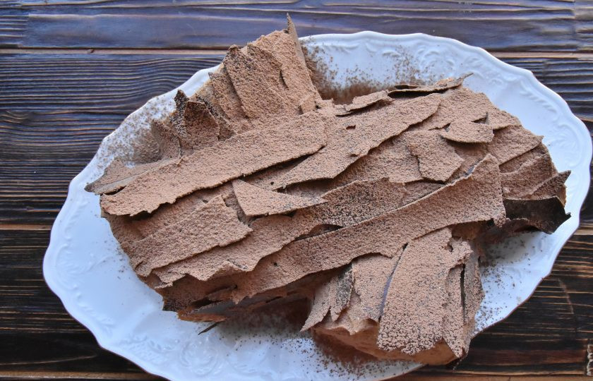 1. Этап. Торт Рождественское полено: Кусочками шоколада оформите торт. Сверху присыпьте торт порошком какао через мелкое сито.