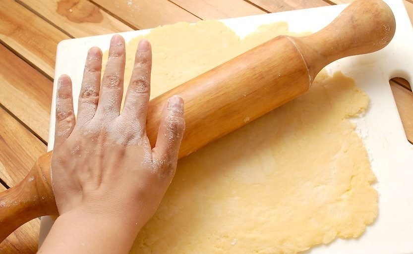 1. Этап. Пирог с яблоками (открытый): Тесто скатываем в шар, делим на две части. Одну заворачиваем в пленку и отправляем на 30 минут в холодильник, а вторую раскатываем в тонкий пласт на поверхности, присыпанной мукой.