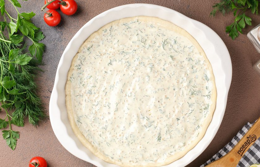 1. Этап. Пицца с горчичным соусом: Я буду готовить две пиццы диаметром 27 см. Тесто разделите и тонко раскатайте на присыпанной мукой поверхности. Перенесите в смазанную маслом форму, руками сформируйте бортики и наколите тесто вилкой, чтобы оно в процессе не вздулось. Смажьте горчичным соусом.