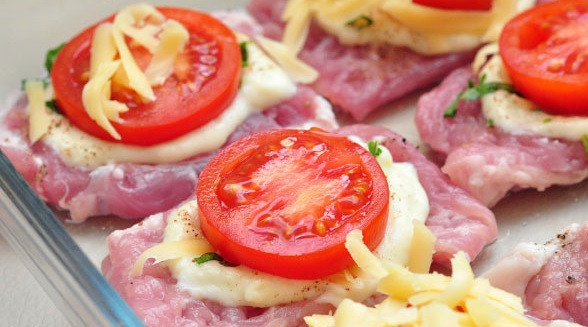 1. Этап. Мясо по-французски без майонеза: 4. Помидоры вымыть, обсушить и нарезать колечками. Разложить на мясо, при желании немного подсолив и поперчив их по вкусу. Сыр натереть на средней или крупной терке и засыпать сверху. Отправить форму в заранее разогретую духовку, при желании накрыв верх фольгой.