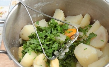 1. Этап. Картофельные зразы с сыром: Из картофеля слейте воду, растолчите его вместе с яйцом, зеленью и сливочным маслом. Всё остудите.