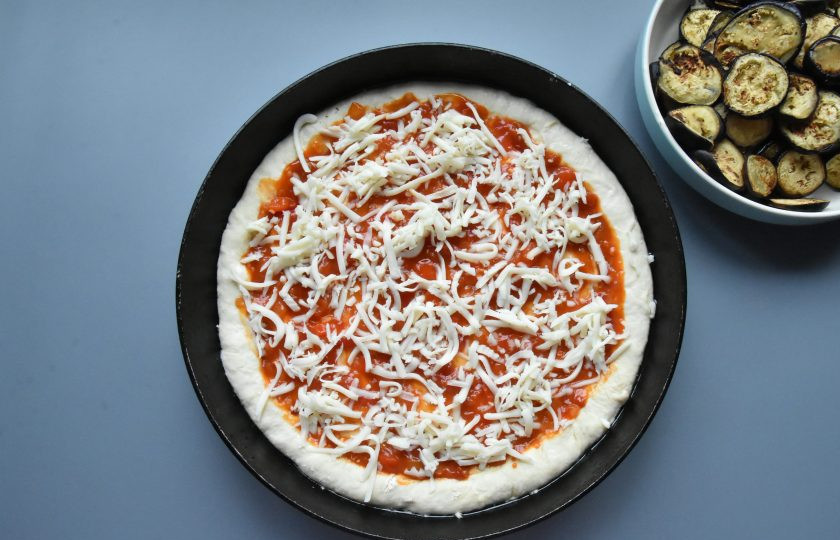 1. Этап. Пицца Меланзанья: Баклажаны обжарьте в сухой сковороде или на гриле. По желанию можно слегка смазать сковороду растительным маслом, но совсем немного. Распределите по поверхности теста томатный соус. Сверху разложите натертую на терке или порванную на кусочки моцареллу.