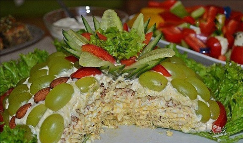 1. Этап. Салат Тифани: Салат собираем в следующей последовательности: курица, смазанная майонезом, часть орехов, яйца, смазанные майонезом, сыр с майонезом и по верху украшаем половинками ягод винограда и целым миндалем. Ставим в холодильник на несколько часов. Затем украшаем зеленью и подаем к столу.