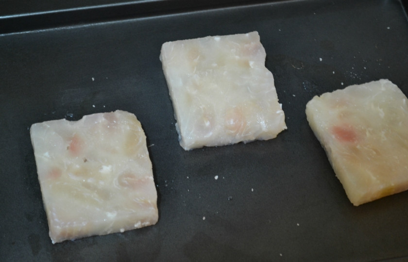 1. Этап. Рыба, запеченная под молочным соусом: Выложите на противень порционные кусочки филе пангасиуса, посолите и поперчите с обеих сторон.