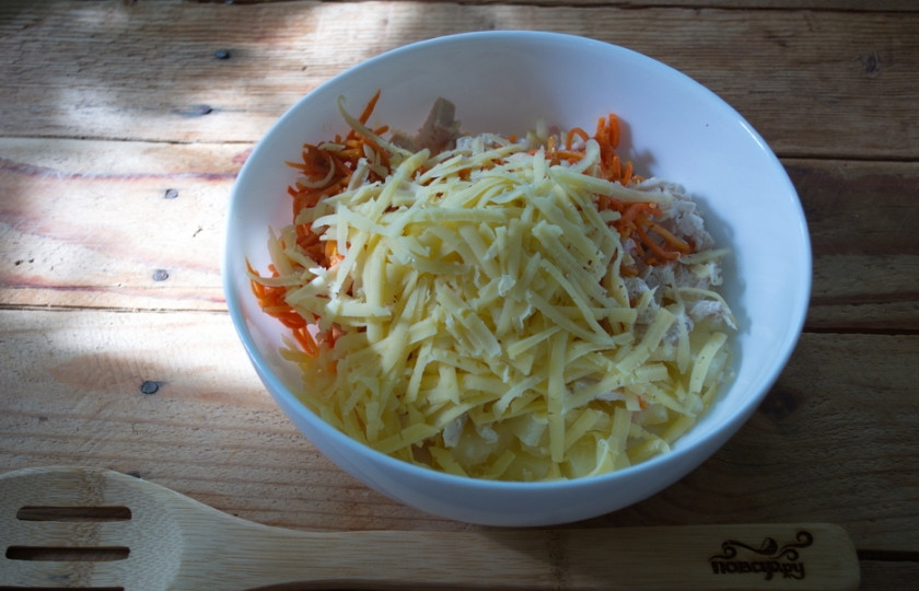 1. Этап. Салат Озорной цыпленок: На терке натрите твердый сыр, добавьте его в салатницу.