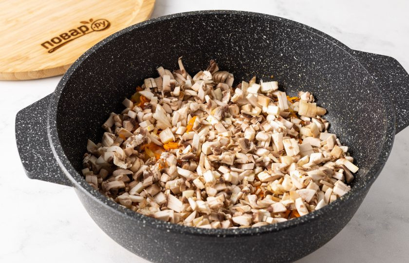 1. Этап. Грибная подлива из шампиньонов: Шампиньоны промойте, обсушите и порежьте на мелкие кубики. Добавьте в сковороду и тушите 15-20 минут под крышкой.