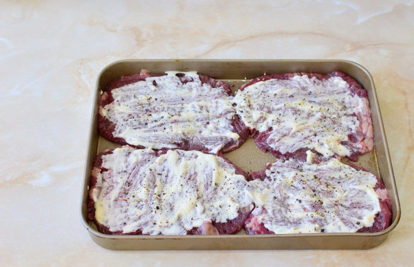 1. Этап. Телятина в духовке с ананасами: Форму для запекания смажьте растительным маслом и выложите отбитое мясо. Смажьте его майонезом. По вкусу посыпьте солью и специями. Учитывайте, что майонез уже содержит соль.