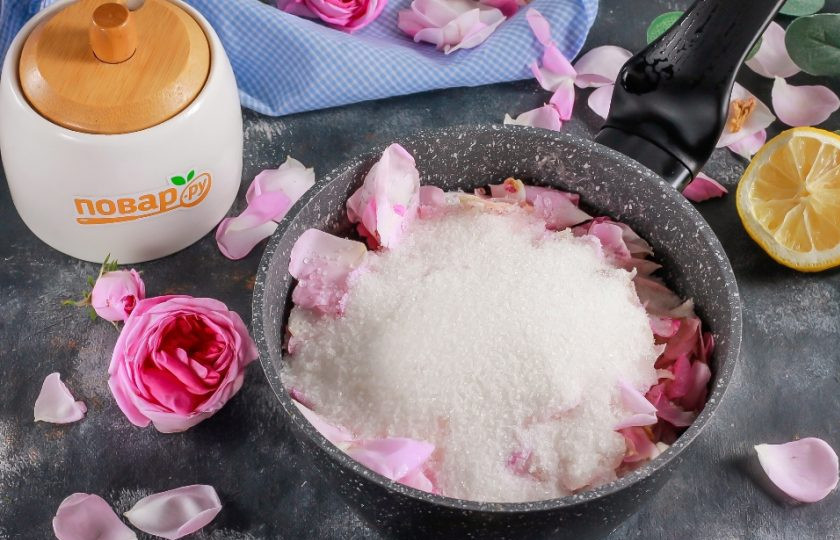 1. Этап. Варенье из розовых лепестков: Высыпьте розовые лепестки в казан или в ковш с антипригарным дном. Влейте теплую воду и всыпьте сахарный песок. Обязательно добавьте лимонный сок, он подчеркнет аромат и вкус розовых лепестков и не даст сахару кристаллизироваться.