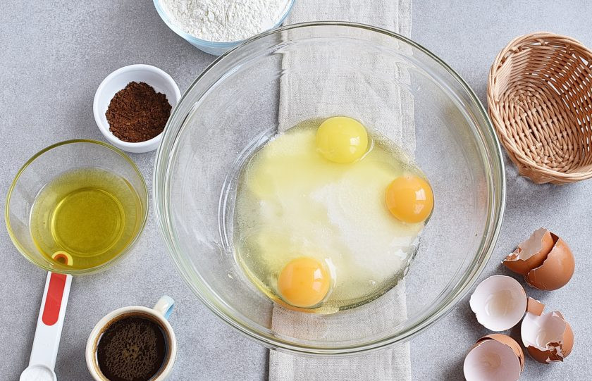 1. Этап. Кофейный пирог: Включите духовку на разогрев до температуры 170 градусов. Взбейте яйца с сахаром до увеличения объема втрое и образования пышной пены.