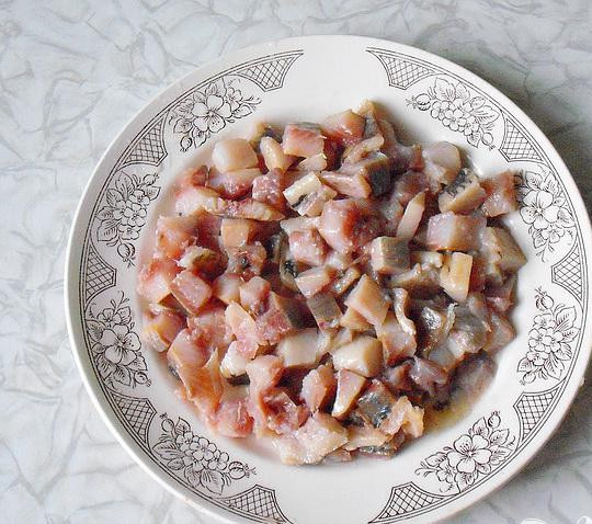 1. Этап. Рулет с сельдью на Старый Новый год: 1. Для начала выпотрошим сельдь, очистим ее от шкуры, кости вынимаем, небольшими кубиками нарезаем и укладываем в тарелку. Немного сбрызнем соком лимона.