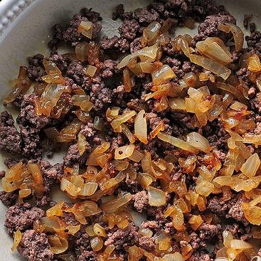 1. Этап. Фритата Чизбургер: 3. Равномерно выложить говядину на дно формы для выпечки и посыпать сверху обжаренным луком. Добавить дополнительную начинку на выбор при желании.