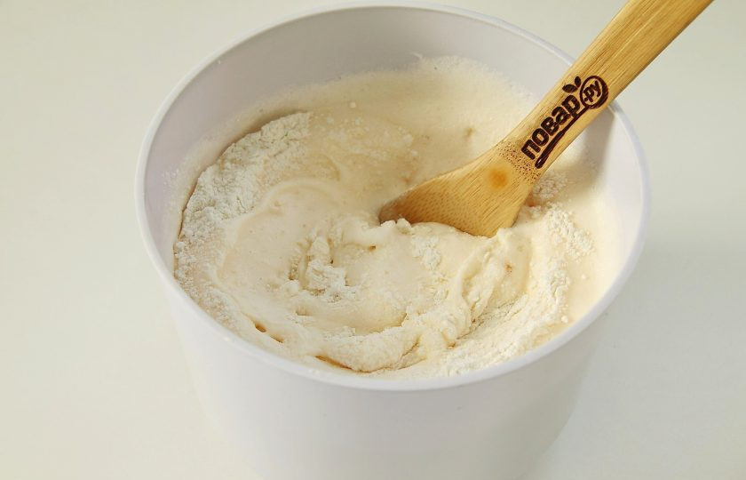 1. Этап. Сырный бисквит: Добавьте частями просеянную муку. Вмешайте муку в тесто ложкой или лопаткой движения снизу вверх.