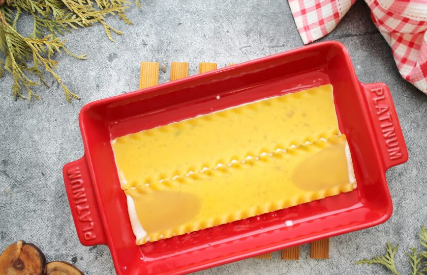 1. Этап. Лазанья Карбонара: Листы лазаньи отварите в кипящей и соленой воде в течение 4-5 минут, откиньте на сито и дайте воде полностью стечь. В форму для выпечки налейте немного молочного соуса и выложите первый слой лазаньи.