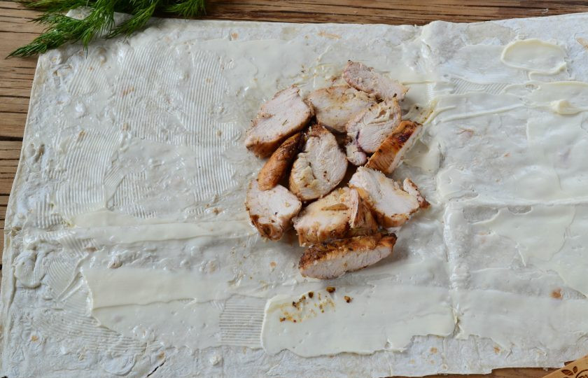 1. Этап. Шаверма с пикантной курочкой и чесночным соусом: На середину выложите порезанную на небольшие кусочки грудку.
