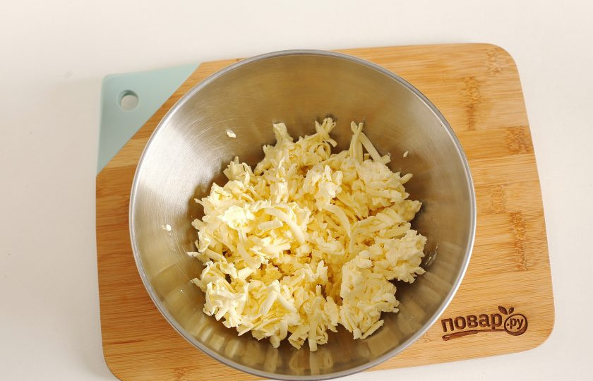 1. Этап. Ложное слоеное тесто: Масло натрите на крупной терке. Чтобы удобнее это было сделать, заранее подержите его в морозилке.