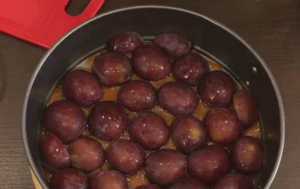 1. Этап. Очень вкусный сливовый пирог-перевертыш: 6. Срезом вниз выложите сливы в один слой. А затем вылейте тесто и разровняйте его до краев формы.