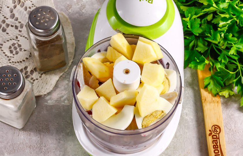 1. Этап. Форшмак со свеклой: Яблоко разрежьте на несколько частей и удалите косточки, промойте и нарежьте ломтиками вместе с очищенным отварным яйцом. Выложите в емкость измельчителя.